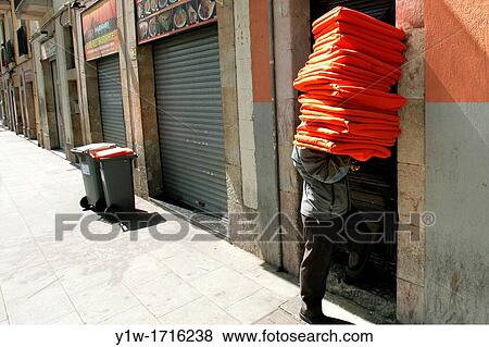 Man carrying cushions. Raval district, Barcelona, Spain View Large Photo Image Stock Photo - Man carrying cushions. Raval district, Barcelona, Spain. Fotosearch