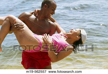 man carrying girl at the beach View Large Photo Image Stock Photo - man carrying girl at the beach. Fotosearch