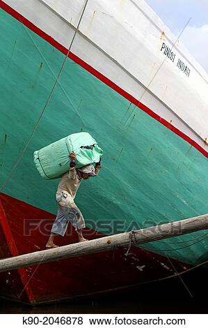 Man carrying goods on his back to load a cargo ship, Sunda Kelapa, Jakarta, Indonesia, Southeast Asia. View Large Photo Image Stock Photo - Man carrying goods on his back to load a cargo ship, Sunda Kelapa, Jakarta, Indonesia, Southeast Asia.. Fotosearch