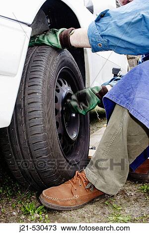 Man changing the tires of a car. View Large Photo Image Stock Image - Man changing the tires of a car.. Fotosearch