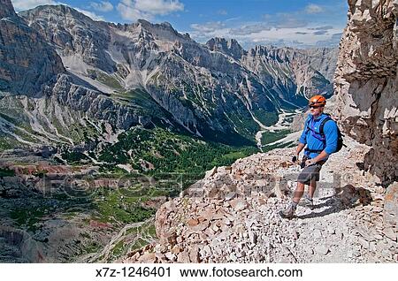 Man climbing the Giovanni Lipella via ferrata on Tofana De Rozes in the Dolomite Mountains near the city of Cortina in northern Italy View Large Photo Image Stock Image - Man climbing the Giovanni Lipella via ferrata on Tofana De Rozes in the Dolomite Mountains near the city of Cortina in northern Italy. Fotosearch