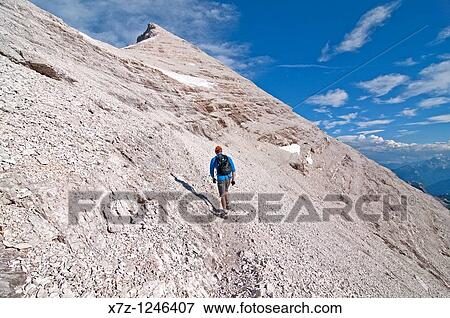 Man climbing the Giovanni Lipella via ferrata on Tofana De Rozes in the Dolomite Mountains near the city of Cortina in northern Italy View Large Photo Image Stock Photo - Man climbing the Giovanni Lipella via ferrata on Tofana De Rozes in the Dolomite Mountains near the city of Cortina in northern Italy. Fotosearch