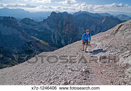 Man climbing the Giovanni Lipella via ferrata on Tofana De Rozes in the Dolomite Mountains near the city of Cortina in northern Italy View Large Photo Image Stock Photograph - Man climbing the Giovanni Lipella via ferrata on Tofana De Rozes in the Dolomite Mountains near the city of Cortina in northern Italy. Fotosearch