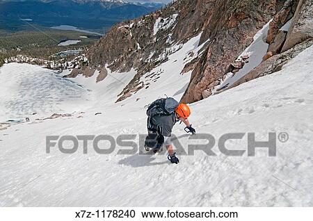 Stock Image - Man climbing the Petzoldt Couloir on Mount Heyburn high in the Sawtooth Mountains of central Idaho. Fotosearch