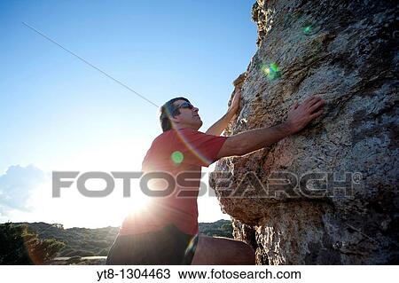 Man climbing up over rocks View Large Photo Image Stock Image - Man climbing up over rocks. Fotosearch