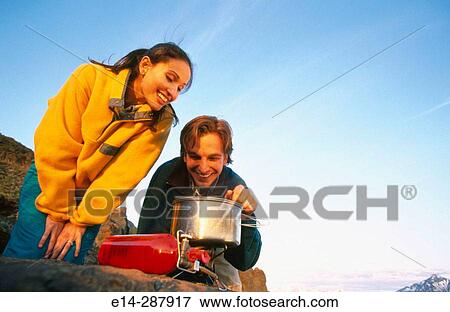 Stock Photo - Man cooking meal on stove. Eagle River Valley. Southcentral Alaska. Fotosearch