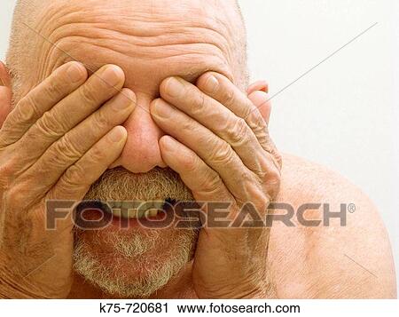Stock Image - Man covering his eyes with his hands. Fotosearch