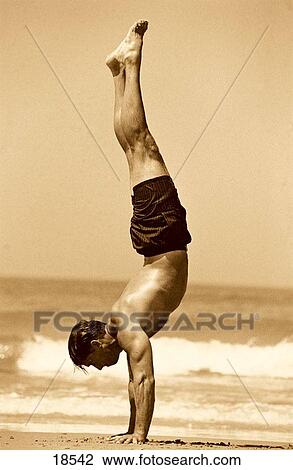 Man doing handstand on the beach View Large Photo Image Stock Image - Man doing handstand on the beach. Fotosearch