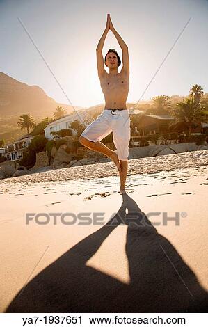 Stock Image - Man Doing Yoga On The Beach. Fotosearch