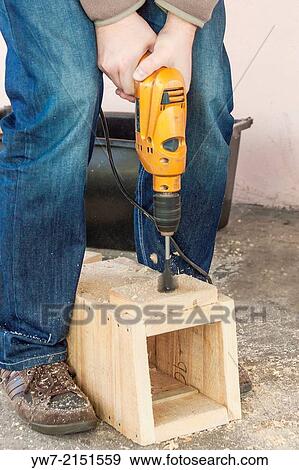 Man drilling a hole in birdhouse. View Large Photo Image Stock Photo - Man drilling a hole in birdhouse.. Fotosearch