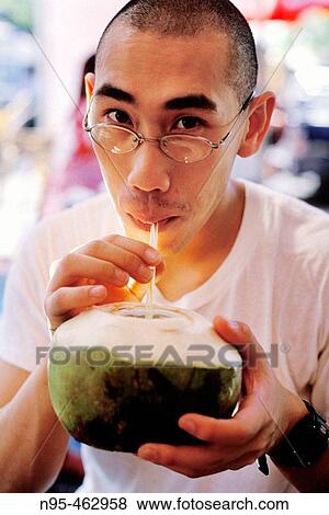 Man drinking coconut milk. Jatujak market. Bangkok, Thailand. View Large Photo Image Stock Photo - Man drinking coconut milk. Jatujak market. Bangkok, Thailand.. Fotosearch