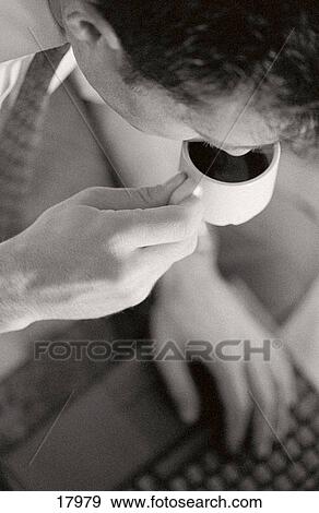 Man drinking espresso on laptop View Large Photo Image Stock Photo - Man drinking espresso on laptop. Fotosearch
