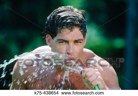Man drinking from garden hose View Large Photo Image Picture - Man drinking from garden hose. Fotosearch
