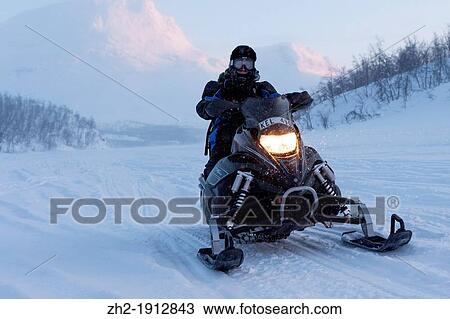 Man driving snowmobile in mountain area in Swedish lapland View Large Photo Image Stock Image - Man driving snowmobile in mountain area in Swedish lapland. Fotosearch