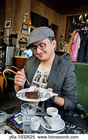 Man eating a cake in cafe View Large Photo Image Stock Photography - Man eating a cake in cafe. Fotosearch