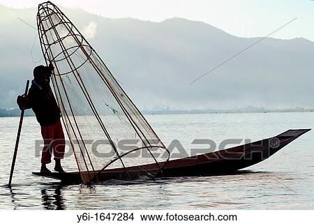 Picture - Man fishing from small boat at Inle Lake in Burma Myanmar. Fotosearch