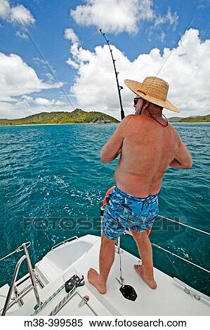 Man fishing off the back of a catamaran while sailing in Antigua View Large Photo Image Stock Photography - Man fishing off the back of a catamaran while sailing in Antigua. Fotosearch