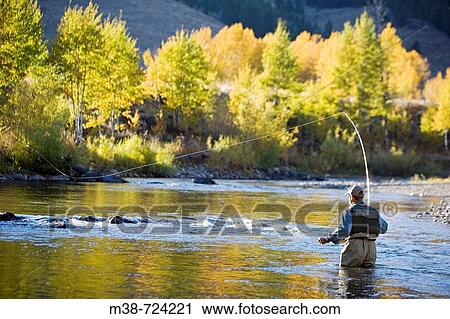 Stock Image - Man fly fishing on the Bigwood River, Sun Valley, Idaho, USA. Fotosearch