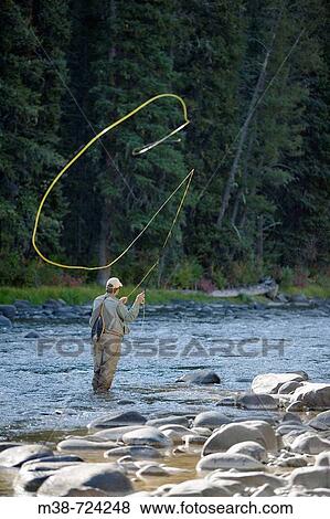Man fly fishing on the Gallatin River, Near Big Sky, Montana, USA View Large Photo Image Stock Photo - Man fly fishing on the Gallatin River, Near Big Sky, Montana, USA. Fotosearch