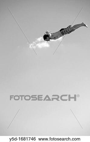 Man flying in the air, actually jumping to the water from tower for jumping into the water View Large Photo Image Stock Photograph - Man flying in the air, actually jumping to the water from tower for jumping into the water. Fotosearch