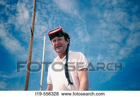 Stock Photo - Man getting ready to jump in from a boat to go snorkeling. Fotosearch