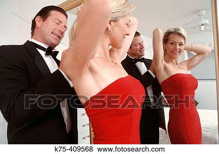 man helping woman put on her jewelry View Large Photo Image Stock Photo - man helping woman put on her jewelry. Fotosearch