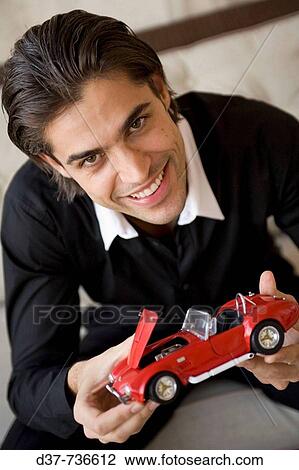 Man holding a collecting miniature car View Large Photo Image Stock Image - Man holding a collecting miniature car. Fotosearch