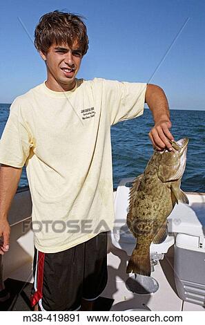 Man holding a fish that he just caught in Marathon, Florida. USA. December 2004. View Large Photo Image Stock Image - Man holding a fish that he just caught in Marathon, Florida. USA. December 2004.. Fotosearch