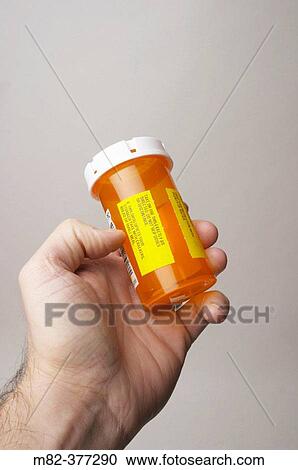 Man holding a prescription pill bottle in his hand. Model-released Image. View Large Photo Image Stock Image - Man holding a prescription pill bottle in his hand. Model-released Image.. Fotosearch