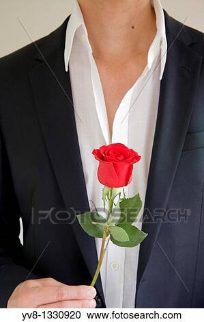Man holding a red rose View Large Photo Image Stock Image - Man holding a red rose. Fotosearch