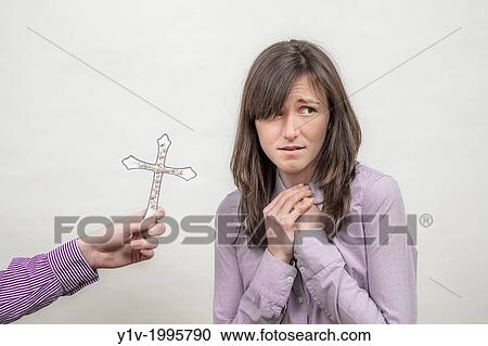 Stock Image - Man holding a religious cross next to a woman.. Fotosearch