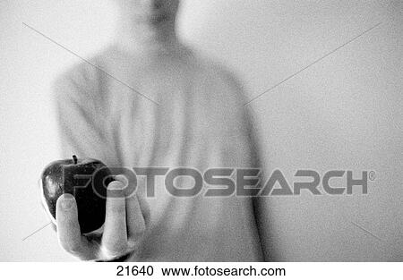 Stock Image - Man holding apple. Fotosearch