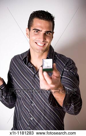 Stock Image - Man Holding Engagement Ring.. Fotosearch