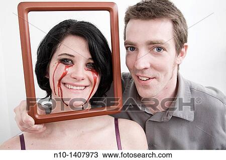Man holding frame in front of wife, who has blood dripping from her eyes View Large Photo Image Stock Image - Man holding frame in front of wife, who has blood dripping from her eyes. Fotosearch
