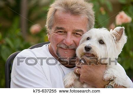 Man holding his pet dog View Large Photo Image Stock Photography - Man holding his pet dog. Fotosearch