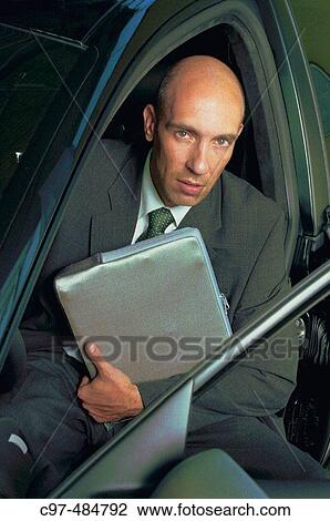 Man holding lapptop bag sitting in car, open door View Large Photo Image Stock Image - Man holding lapptop bag sitting in car, open door. Fotosearch