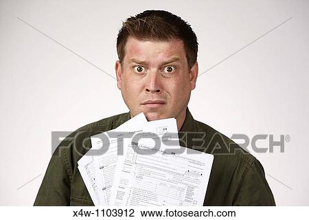 Man holding United States 1040 tax forms and feeling anxious about his taxes View Large Photo Image Stock Image - Man holding United States 1040 tax forms and feeling anxious about his taxes. Fotosearch