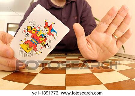 Man holding up a joker playing card View Large Photo Image Stock Image - Man holding up a joker playing card. Fotosearch