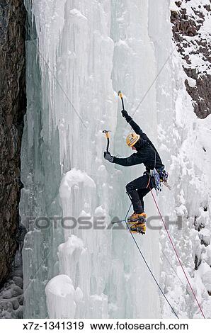 Stock Photo - Man ice climbing a route called Genesis which is rated WI, 5 and located in Hyalite Canyon near the city of Bozeman in western Montana. Fotosearch