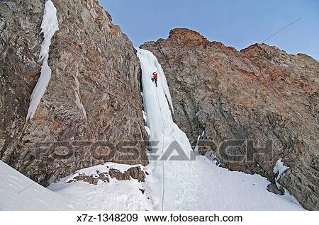 Stock Photo - Man ice climbing a route which is rated WI4 near Silver Creek high in the Boulder Mountains in central Idaho. Fotosearch