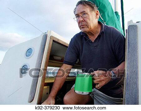 Stock Image - Man in a sailboat. Fotosearch