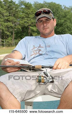 Man in his 30's fishing and reading a book at the same time looking bored View Large Photo Image Stock Image - Man in his 30's fishing and reading a book at the same time looking bored. Fotosearch