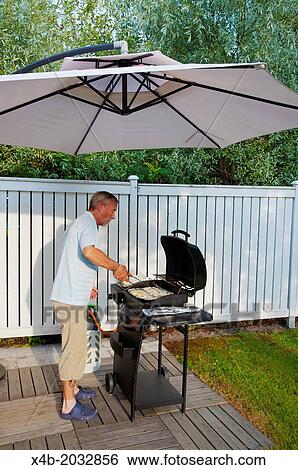 Man in his 70s grilling fish in garden western Finland northern Europe. View Large Photo Image Stock Photograph - Man in his 70s grilling fish in garden western Finland northern Europe.. Fotosearch