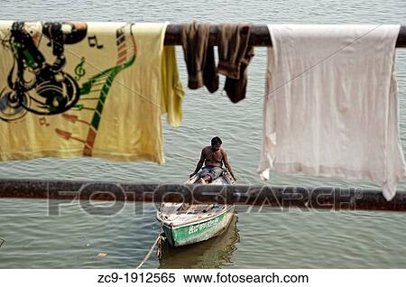 Man in his boat on the Ganges river and clothes drying Varanasi, Benares, Uttar Pradesh, India View Large Photo Image Stock Photography - Man in his boat on the Ganges river and clothes drying Varanasi, Benares, Uttar Pradesh, India. Fotosearch