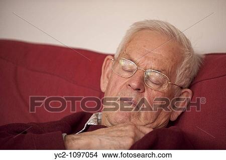 Man in his early eighties asleep sitting in a chair in the Uk View Large Photo Image Picture - Man in his early eighties asleep sitting in a chair in the Uk. Fotosearch