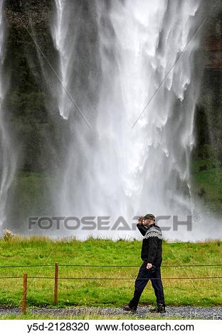 Man in Icelandic sweater walking near Seljalandsfoss waterfall, Iceland View Large Photo Image Stock Image - Man in Icelandic sweater walking near Seljalandsfoss waterfall, Iceland. Fotosearch