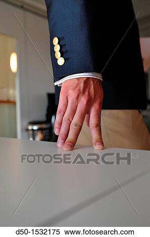 Stock Photography - Man in jacket rests fingers on table (Notice: Four button, four fingers), Stockholm, Sweden. Fotosearch
