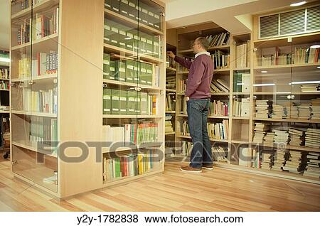 Man in library, at work View Large Photo Image Stock Photo - Man in library, at work. Fotosearch