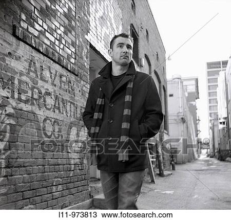 Man in peacoat, walking through alley. View Large Photo Image Stock Image - Man in peacoat, walking through alley.. Fotosearch