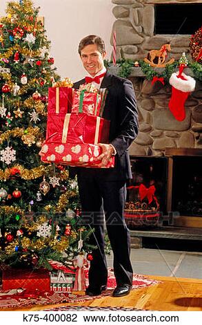 Man in tux with Christmas presents View Large Photo Image Stock Image - Man in tux with Christmas presents. Fotosearch